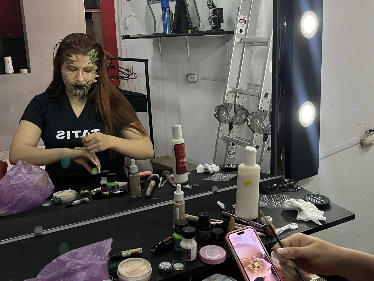 Sesión de maquillaje escénico frente al espejo de camerino